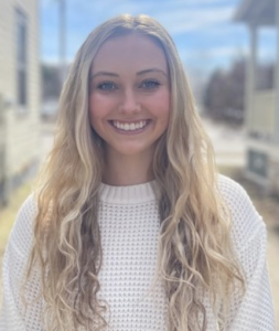 A woman in a white sweater smiles. 